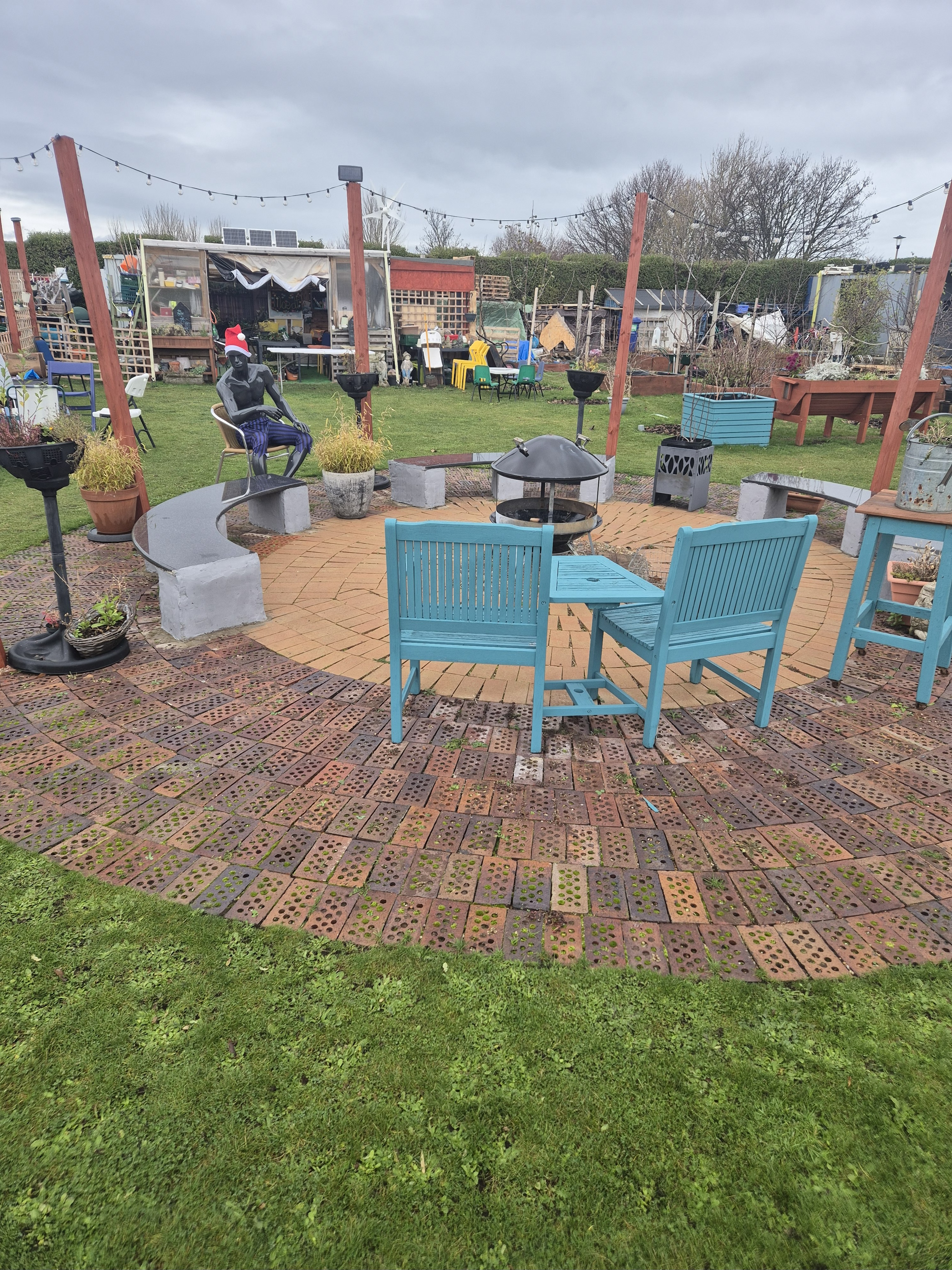 A garden with chairs and a fire pit
