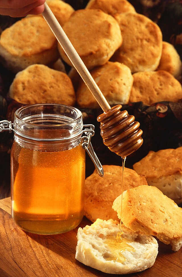 A jar of honey and a stirrer